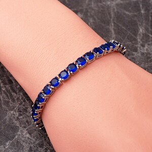 A handcrafted 925 sterling silver 5mm tennis bracelet featuring sparkling gemstone accents in a sleek prong setting.