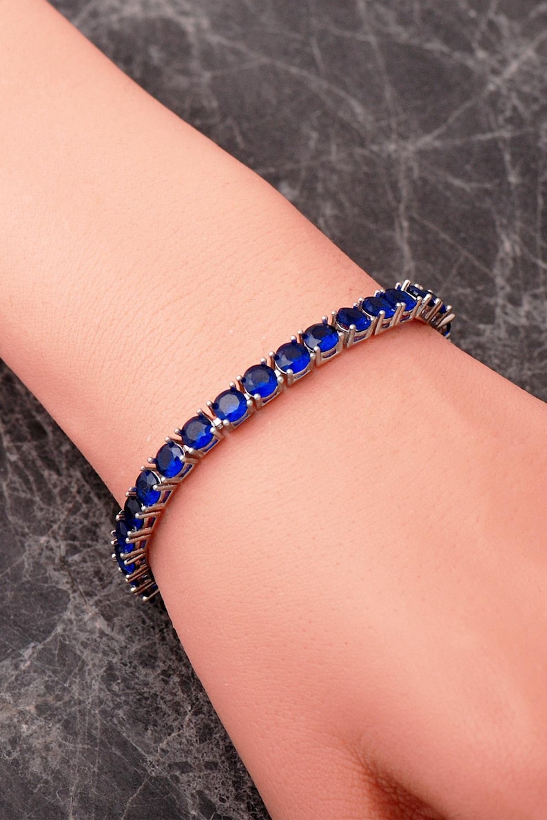 A handcrafted 925 sterling silver 5mm tennis bracelet featuring sparkling gemstone accents in a sleek prong setting.