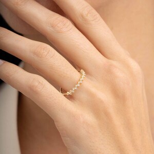 A thin 3mm wide silver ring coated in green gold plating with sparkling clear cubic zirconia stones set around the band.