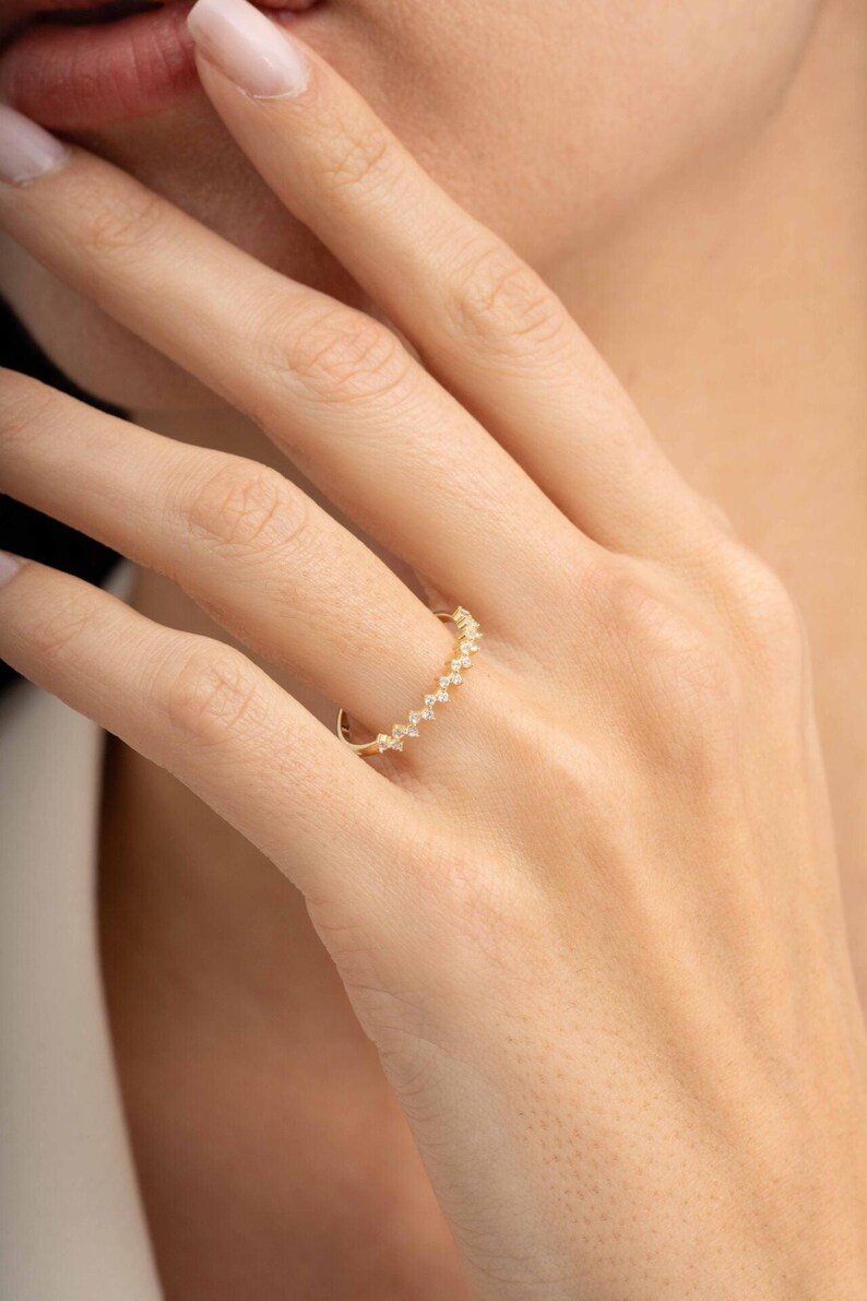 A thin 3mm wide silver ring coated in green gold plating with sparkling clear cubic zirconia stones set around the band.