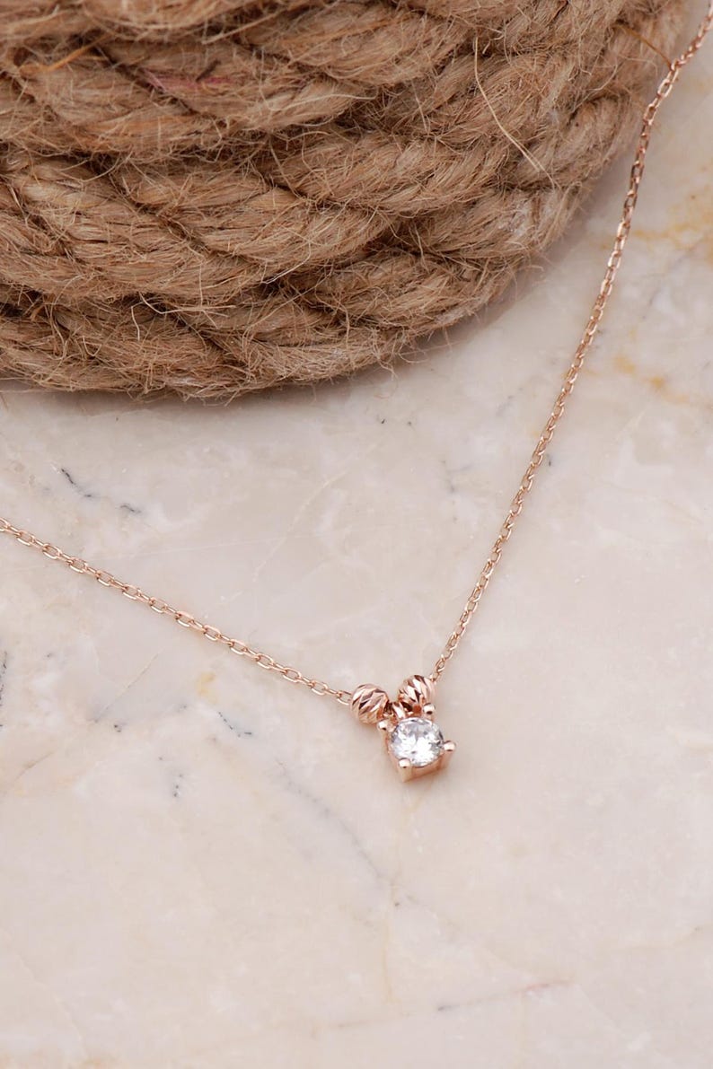 A rose‑gold plated hair coil made of 925 sterling silver, adorned with small cubic zirconia stones, measuring about 23 cm in length.