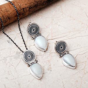 Handmade 925 sterling silver teardrop jewelry set featuring a mother of pearl pendant necklace and matching drop earrings adorned with intricate vintage motifs and an oxidized silver finish.