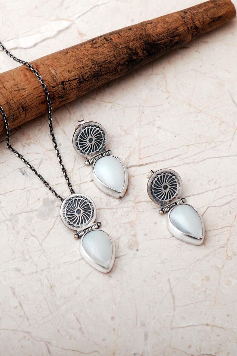 Handmade 925 sterling silver teardrop jewelry set featuring a mother of pearl pendant necklace and matching drop earrings adorned with intricate vintage motifs and an oxidized silver finish.