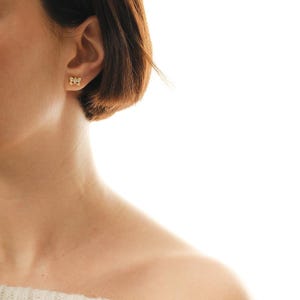 Mini butterfly earrings made of 925 sterling silver with green gold rhodium plating and white zircon stones, measuring 6 mm tall by 9 mm wide.