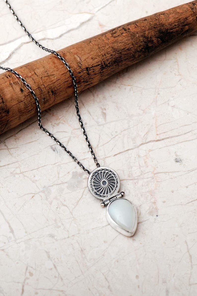 Handmade 925 sterling silver teardrop jewelry set featuring a mother of pearl pendant necklace and matching drop earrings adorned with intricate vintage motifs and an oxidized silver finish.
