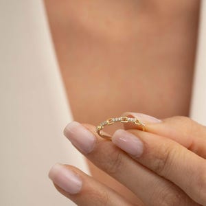 A delicate gold-plated 925 sterling silver chain link band ring encrusted with sparkling clear cubic zirconia stones against a neutral background.