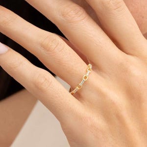 A delicate gold-plated 925 sterling silver chain link band ring encrusted with sparkling clear cubic zirconia stones against a neutral background.
