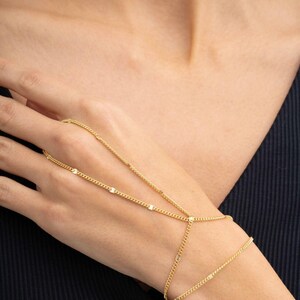A delicate double-wrap gold-plated 925 sterling silver Sahmeran hand chain with hand-engraved curb chain detailing that sparkles like gemstones.