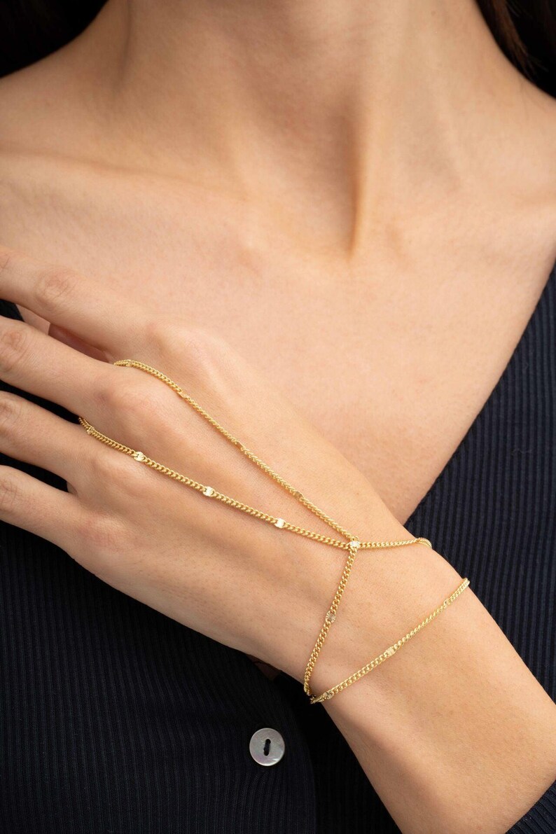 A delicate double-wrap gold-plated 925 sterling silver Sahmeran hand chain with hand-engraved curb chain detailing that sparkles like gemstones.