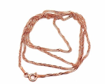 May include: A rose gold-coloured chain necklace featuring a twisted, textured link design. The necklace is constructed with a circular spring ring clasp mechanism at the end, providing a secure closure for the metallic, shimmering jewellery piece.