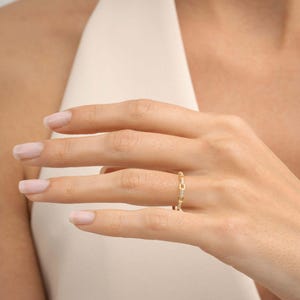 A delicate gold-plated 925 sterling silver chain link band ring encrusted with sparkling clear cubic zirconia stones against a neutral background.