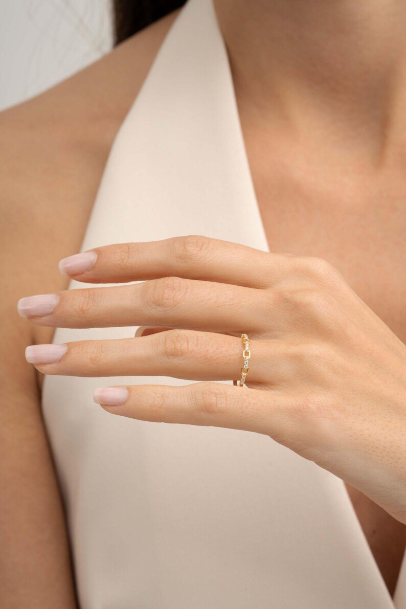 A delicate gold-plated 925 sterling silver chain link band ring encrusted with sparkling clear cubic zirconia stones against a neutral background.