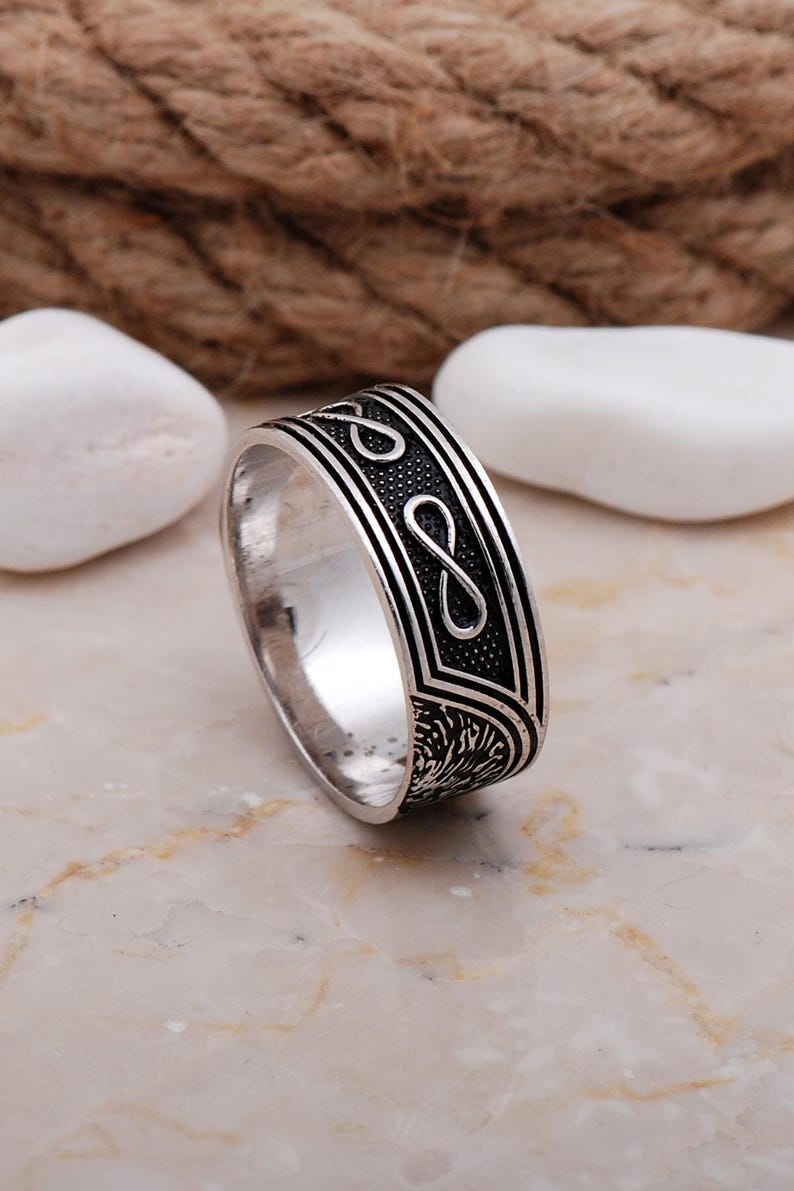 Handmade men's infinity love ring made of 925 sterling silver with a white gold plated finish, showing a smooth 9mm wide band.