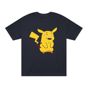 Könnte beinhalten: Ein marineblaues T-Shirt mit einem gelben Pikachu-Cartoon mit einem verschmitzten Grinsen und einem roten Blitzschock-Schwanz.