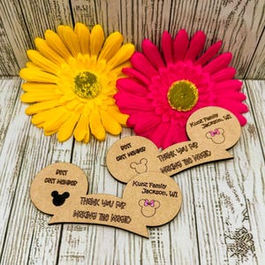 May include: Three wooden Mickey Mouse ear-shaped tags with the text "Thank you for making the magic" and "Best Cast Member". The tags also include the text "Kunz Family Jackson, WI".