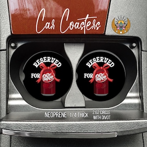 May include: Black car coasters with a Dr. Pepper theme. Each coaster has the words "Reserved for Dr. Pepper" and a graphic of a Dr. Pepper can with a red bow. The coasters are 2.62 inches in diameter and made of neoprene.
