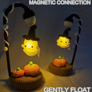 May include: Crocheted Halloween-themed lamp with two ghost-shaped lights wearing witch hats, and two orange pumpkins. The lamp has a black frame with the text "MAGNETIC CONNECTION" and "GENTLY FLOAT".