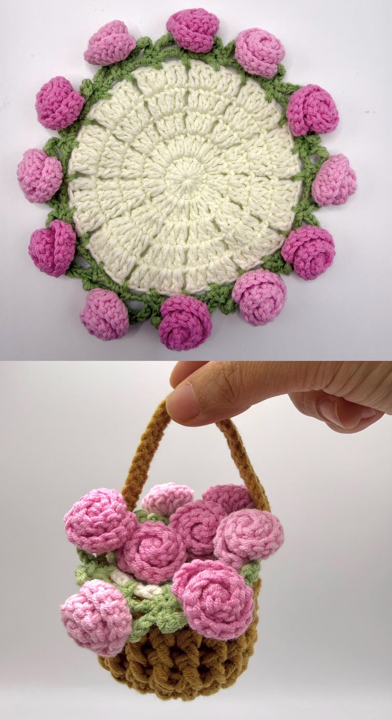 May include: A circular off-white crochet doily featuring a border of green leaves and small pink rose blossoms. Below, a small brown crochet basket with a handle is filled with several pink crocheted rose blossoms and green leaves.