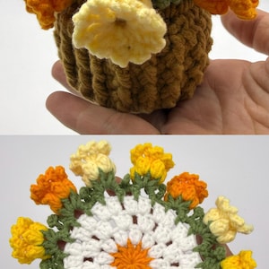 May include: A crochet flower arrangement featuring a brown textured pot filled with yellow and orange blossoms, and a flat circular crochet coaster with a white center, orange star-shaped detail, and a border of small yellow and orange flowers.