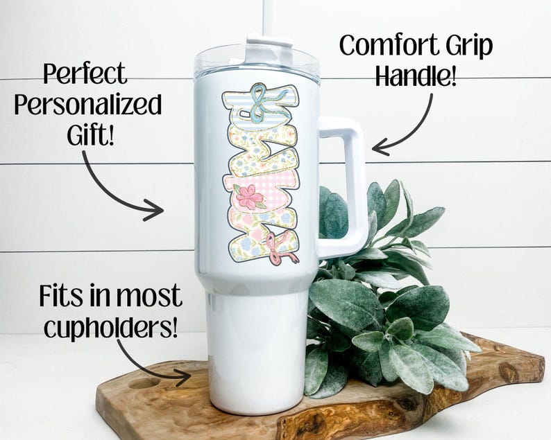 Puede incluir: Vaso blanco con asa y dise&ntilde;o floral "Mama". El vaso tiene tapa blanca y pajita. Tambi&eacute;n se ve el texto "Perfect Personalized Gift!" y "Fits in most cupholders!"