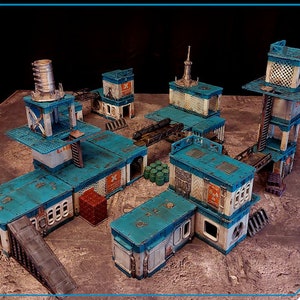 May include: A blue and white industrial-style building set for tabletop gaming. The set includes multiple buildings, a ramp, and a bridge.