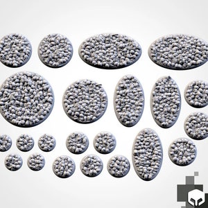 May include: A set of 17 round and oval-shaped bases for miniature figures, featuring a skull design. The bases are made of a light gray material and are perfect for tabletop gaming.