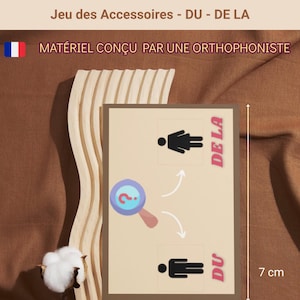 May include: A game card set with the text "Jeu des Accessoires - DU - DE LA" and "MATÉRIEL CONÇU PAR UNE ORTHOPHONISTE". The card is 5 cm wide and 7 cm tall. The set includes 80 cards and is ready to use.