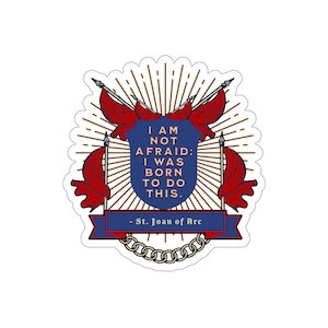 May include: A blue and red shield with a white background and gold accents. The shield has a quote inside: "I am not afraid: I was born to do this." - St. Joan of Arc. The shield is surrounded by red flags and a gold sunburst.