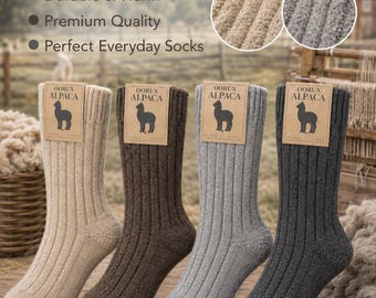 Puede incluir: Cuatro calcetines acanalados en colores beige, marrón, gris y antracita. Cada calcetín tiene una etiqueta de cartón color canela con el texto Qorux Alpaca y una silueta de alpaca. El texto Qorux Alpaca Socks aparece arriba con puntos.