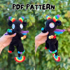 Op de afbeelding: Twee zwarte gehaakte draakspeeltjes met regenbooghoorns, vleugels en voeten. De draken hebben grote, glinsterende ogen. De tekst "PDF PATTERN" staat bovenaan de afbeelding.