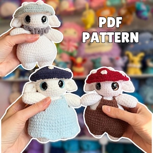 May include: Three handmade crochet dolls with white bodies, each wearing a different hat and outfit. One doll has a gray hat and scarf, another a blue hat and dress, and the third a red mushroom cap and brown overalls. The text "PDF PATTERN" is displayed.