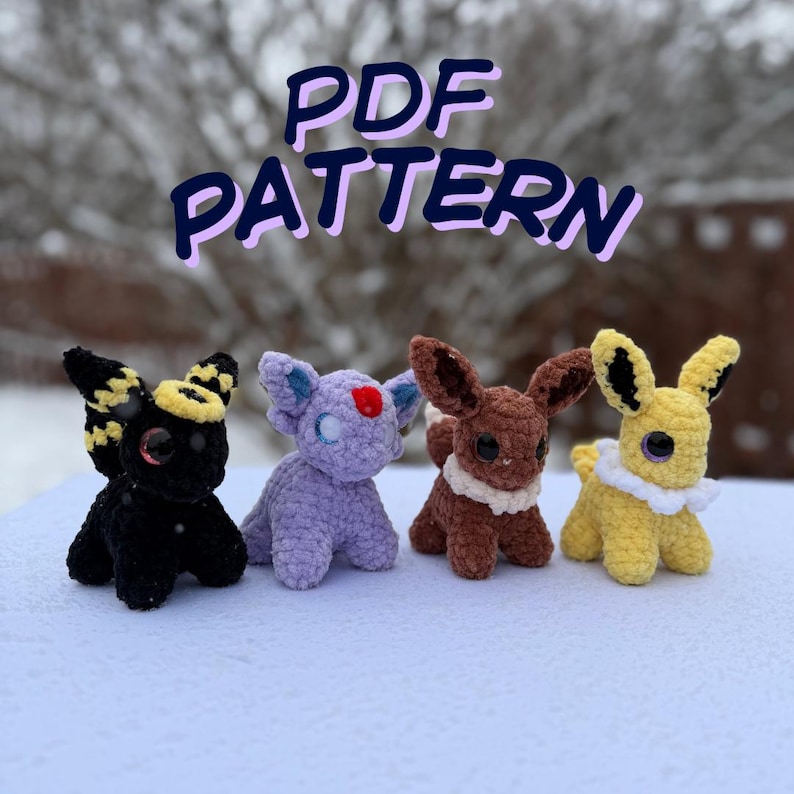 Pu&ograve; includere: Quattro pupazzi all'uncinetto in nero, viola, marrone e giallo, ognuno con grandi occhi e design distintivi delle orecchie. Il testo "PDF PATTERN" &egrave; visualizzato in un carattere viola e blu sopra le figure. Le figure sono su una superficie bianca.