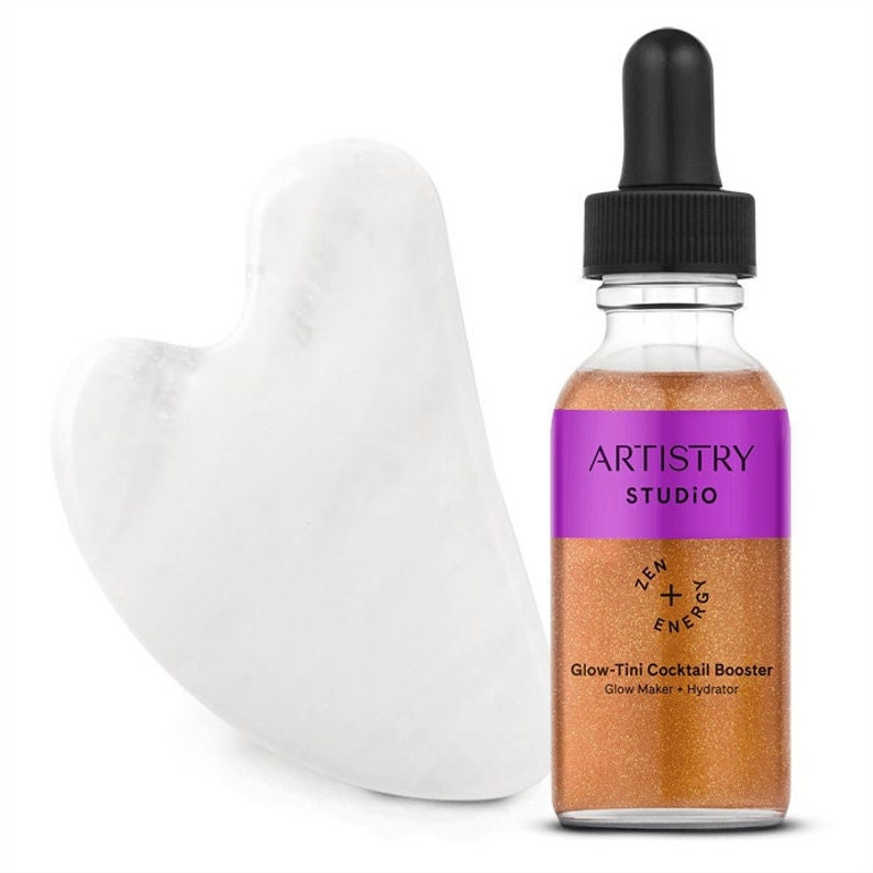 May include: A gold bottle with a purple label that says "Artistry Studio" and "Glow-Tini Cocktail Booster" with a white heart-shaped gua sha tool.