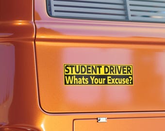 Könnte beinhalten: Ein rechteckiger gelber Aufkleber mit schwarzem Text "STUDENT DRIVER Whats Your Excuse?" ist auf der Rückseite eines orangefarbenen Fahrzeugs angebracht. Der Aufkleber ist zentriert und das Fahrzeug hat ein Fenster mit horizontalen Linien.