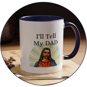 Könnte beinhalten: Weiße Keramik-Kaffeetasse mit blauem Rand und Henkel. Die Tasse zeigt eine Grafik von Jesus mit dem Text "I'll Tell My Dad".