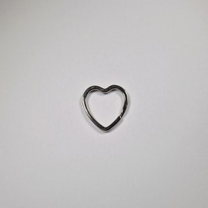 May include: A silver heart-shaped key ring.