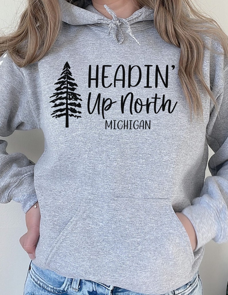 May include: Gray hooded sweatshirt with a black print of a pine tree and the text "Headin' Up North Michigan".