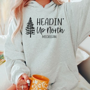 May include: A gray hooded sweatshirt with the text "Headin' Up North Michigan" and a stylized pine tree graphic.