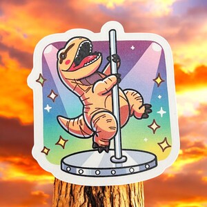 May include: A cartoon illustration of a brown dinosaur in a sparkly setting, performing a pole dance. The dinosaur is holding onto a silver pole with its right hand and its left leg is raised in the air. The dinosaur is wearing a pink blush on its cheeks and has a pink tongue sticking out. The background is a rainbow gradient with white stars.