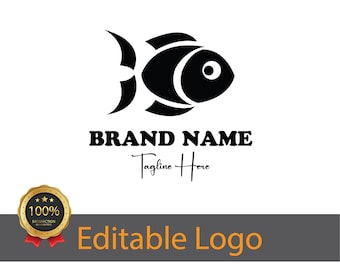 May include: Black and white logo design featuring a stylized fish with a large eye. The text "BRAND NAME" is below the fish, with the tagline "Tagline Here" written in cursive below the brand name.