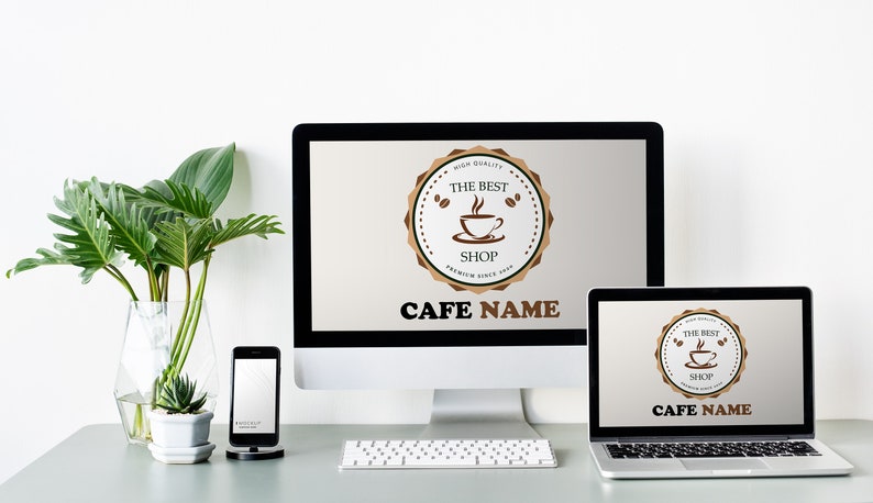 May include: A white desktop computer, a laptop computer, and a smartphone are on a gray table. The desktop computer and laptop have the same logo on their screens, which says "The Best Shop" with a coffee cup icon. The text "Cafe Name" is below the logo. A green plant is in a clear vase on the table.