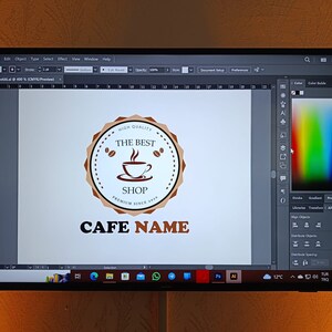 May include: A computer screen displaying a logo design for a cafe. The logo features a brown circle with a coffee cup and the text "High Quality, The Best Shop, Premium Since 2020". The text "Cafe Name" is displayed below the circle.