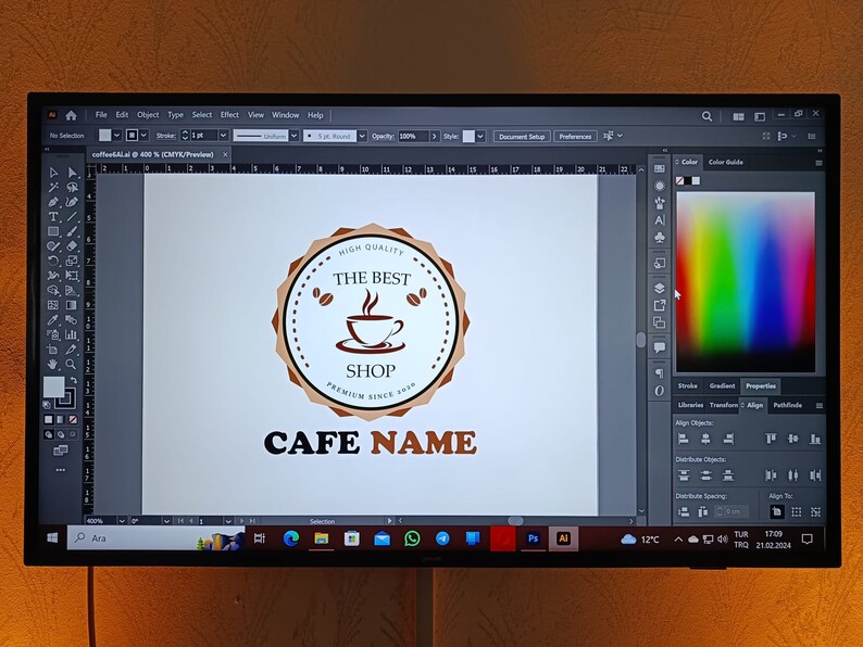 May include: A computer screen displaying a logo design for a cafe. The logo features a brown circle with a coffee cup and the text "High Quality, The Best Shop, Premium Since 2020". The text "Cafe Name" is displayed below the circle.