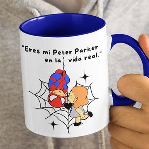 Puede incluir: Taza de cer&aacute;mica blanca con borde y asa azules. La taza presenta una imagen de dibujos animados de Spider-Man y una mujer en una telara&ntilde;a. El texto en la taza dice "Eres mi Peter Parker en la vida real."