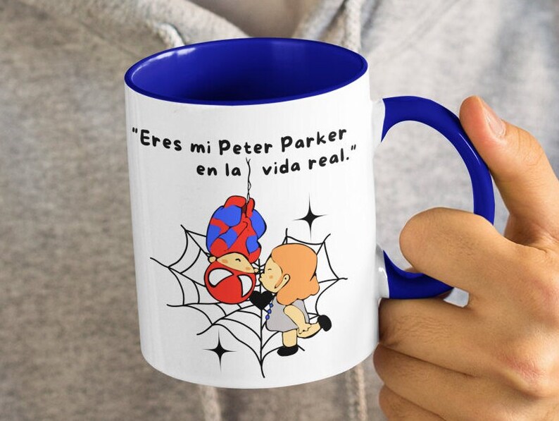 Puede incluir: Taza de cer&aacute;mica blanca con borde y asa azules. La taza presenta una imagen de dibujos animados de Spider-Man y una mujer en una telara&ntilde;a. El texto en la taza dice "Eres mi Peter Parker en la vida real."