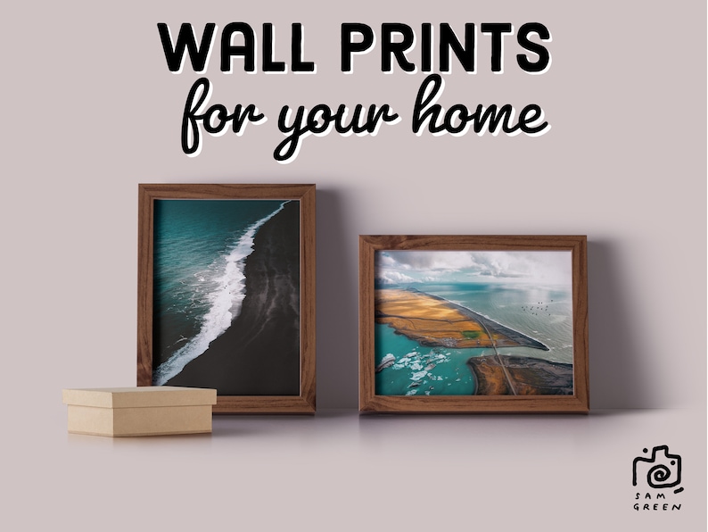 May include: Two framed photographs of aerial landscapes. The first photo shows a black sand beach with a white wave crashing on the shore. The second photo shows a coastline with a river flowing through a field of yellow grass. The text "WALL PRINTS for your home" is at the top of the image.