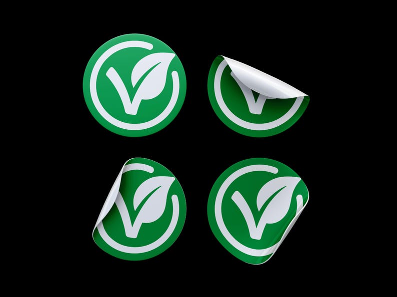 May include: Four green and white round stickers with a leaf and checkmark design. The stickers are partially peeled back to show the white adhesive backing.