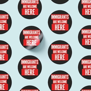 May include: A sheet of round stickers with the text "IMMIGRANTS ARE WELCOME HERE" in white on a red rectangle, set against a black circle. The stickers are scattered on a light blue background.