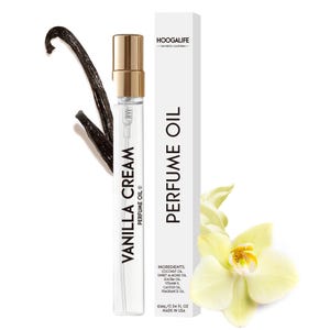 Op de afbeelding: Een klein, doorzichtig glazen flesje met een gouden dop en een etiket met de tekst "Vanilla Cream Perfume Oil". Het flesje staat op een witte achtergrond met een vanilleboon en een witte bloem.