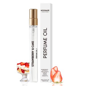 Op de afbeelding: Een doorzichtige glazen fles met een gouden dop en een wit etiket met de tekst "Strawberry & Cake Perfume Oil". De fles staat op een witte achtergrond met een klein glazen schaaltje met aardbeien en slagroom.